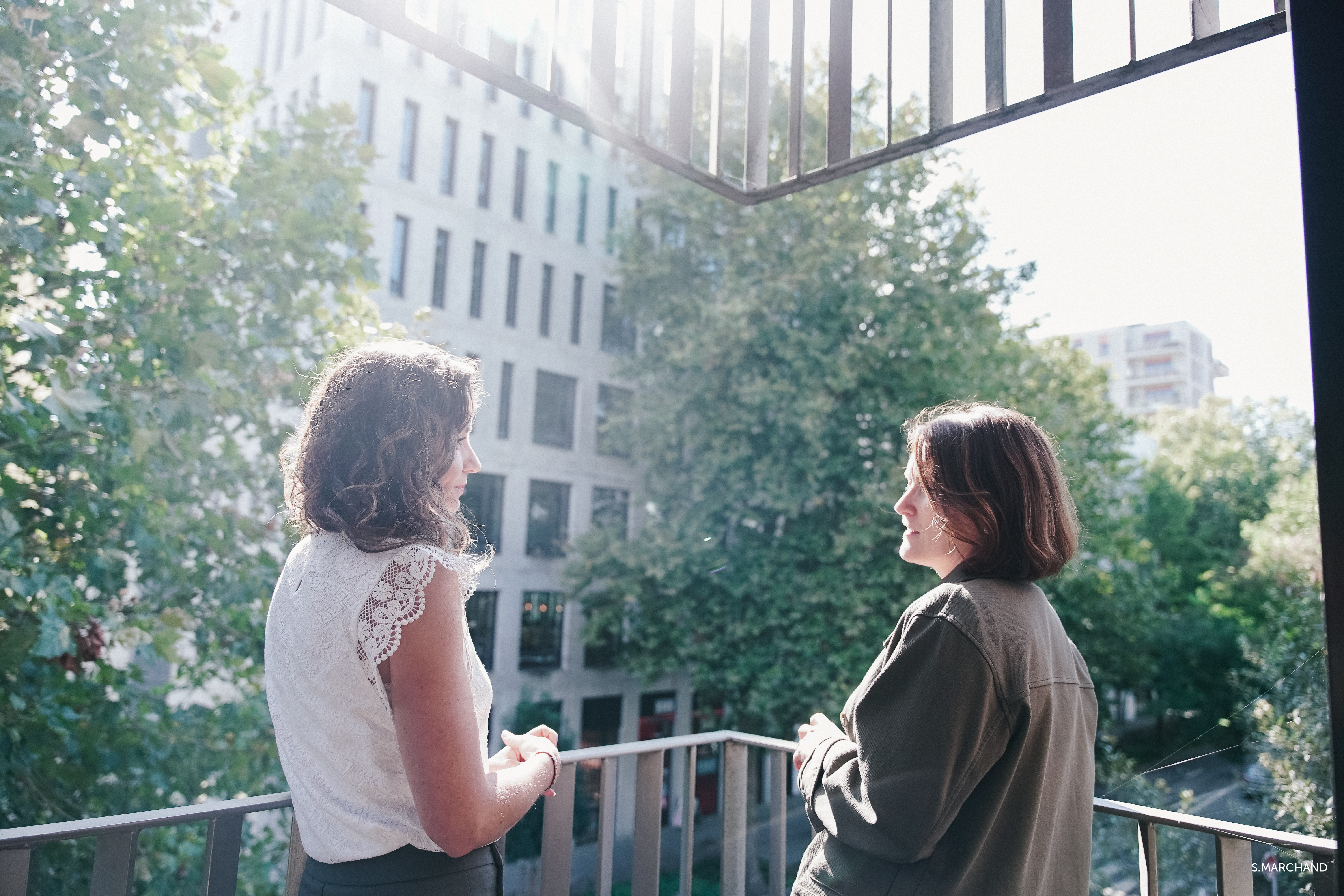 Deux femmes en pleine discussion se tiennent de profil sur le balcon de l'agence de Nantes.